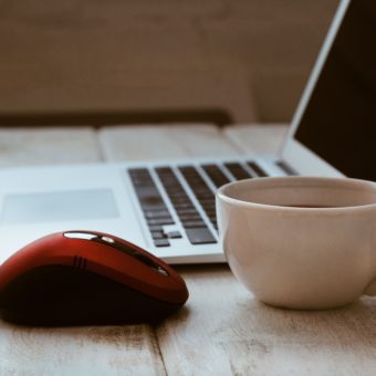 laptop with red mouse and coffee cup